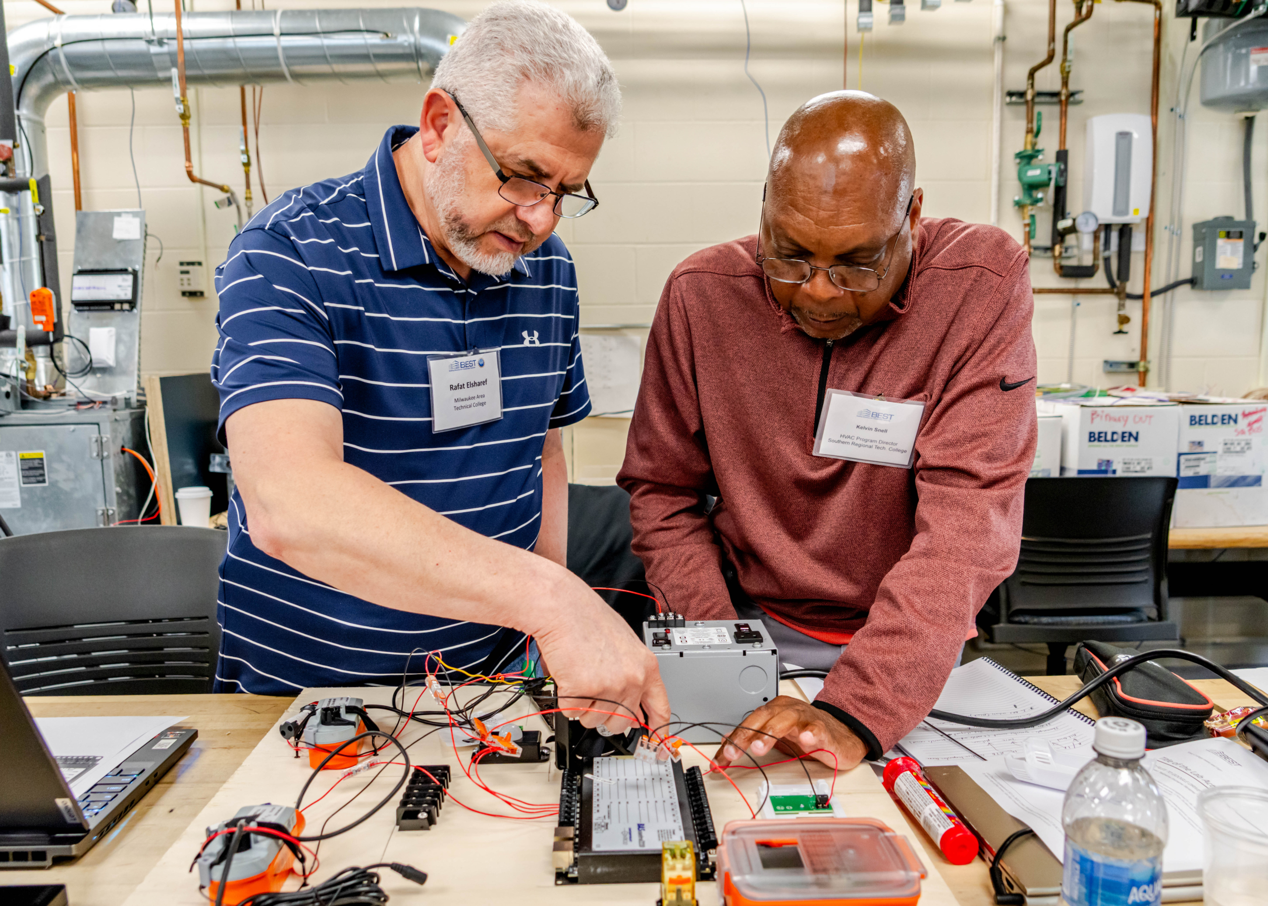 Two faculty participants review the components of a portable building automation trainer