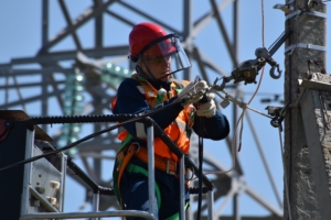 An electrician repairing transmission lines