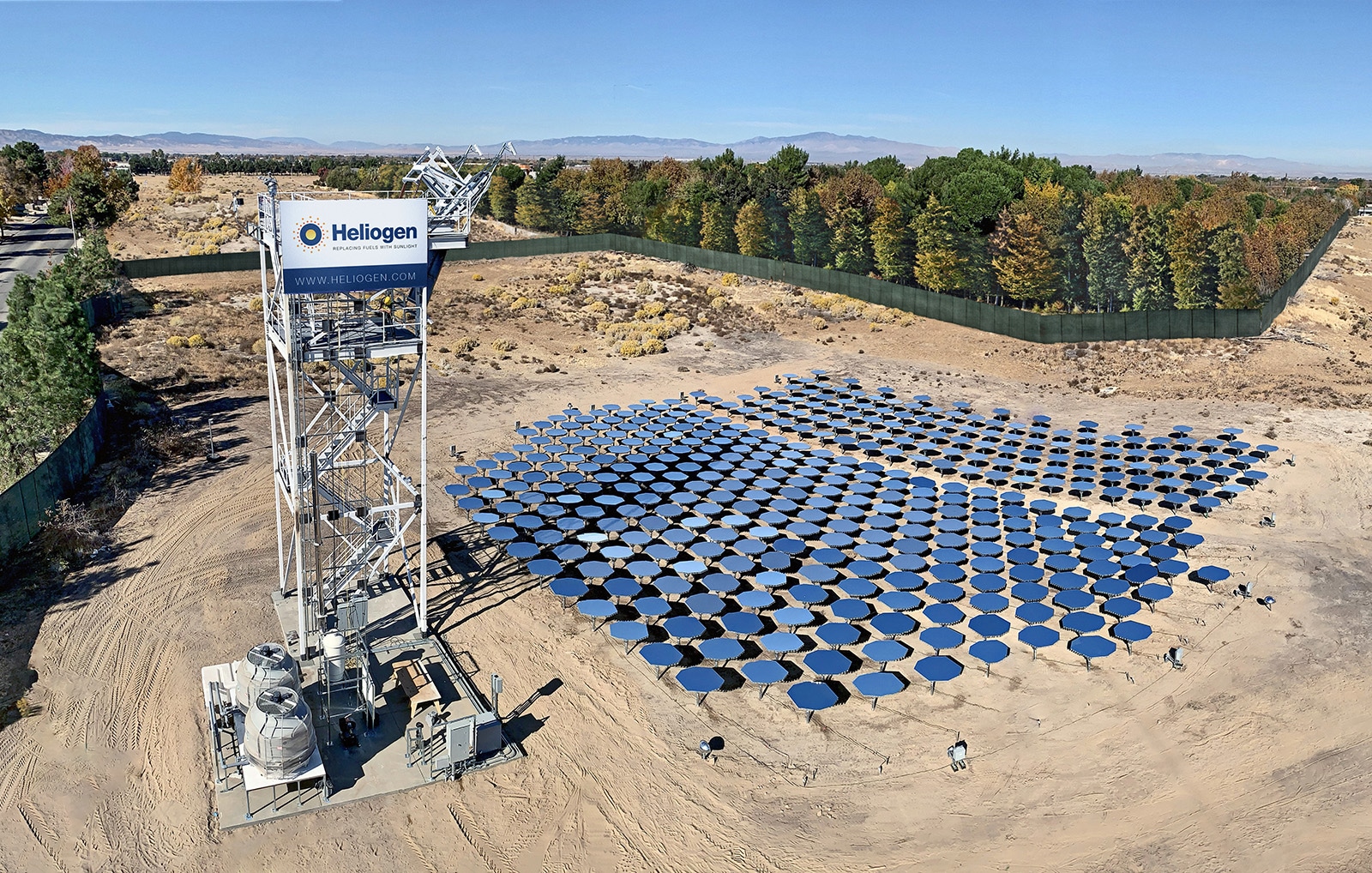 Hundreds of computer-controlled mirrors next to a solar tower in an industrial facility