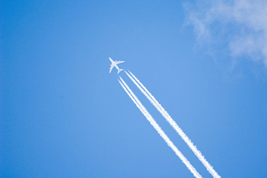 Worm's eye view of a flying plane with two contrails