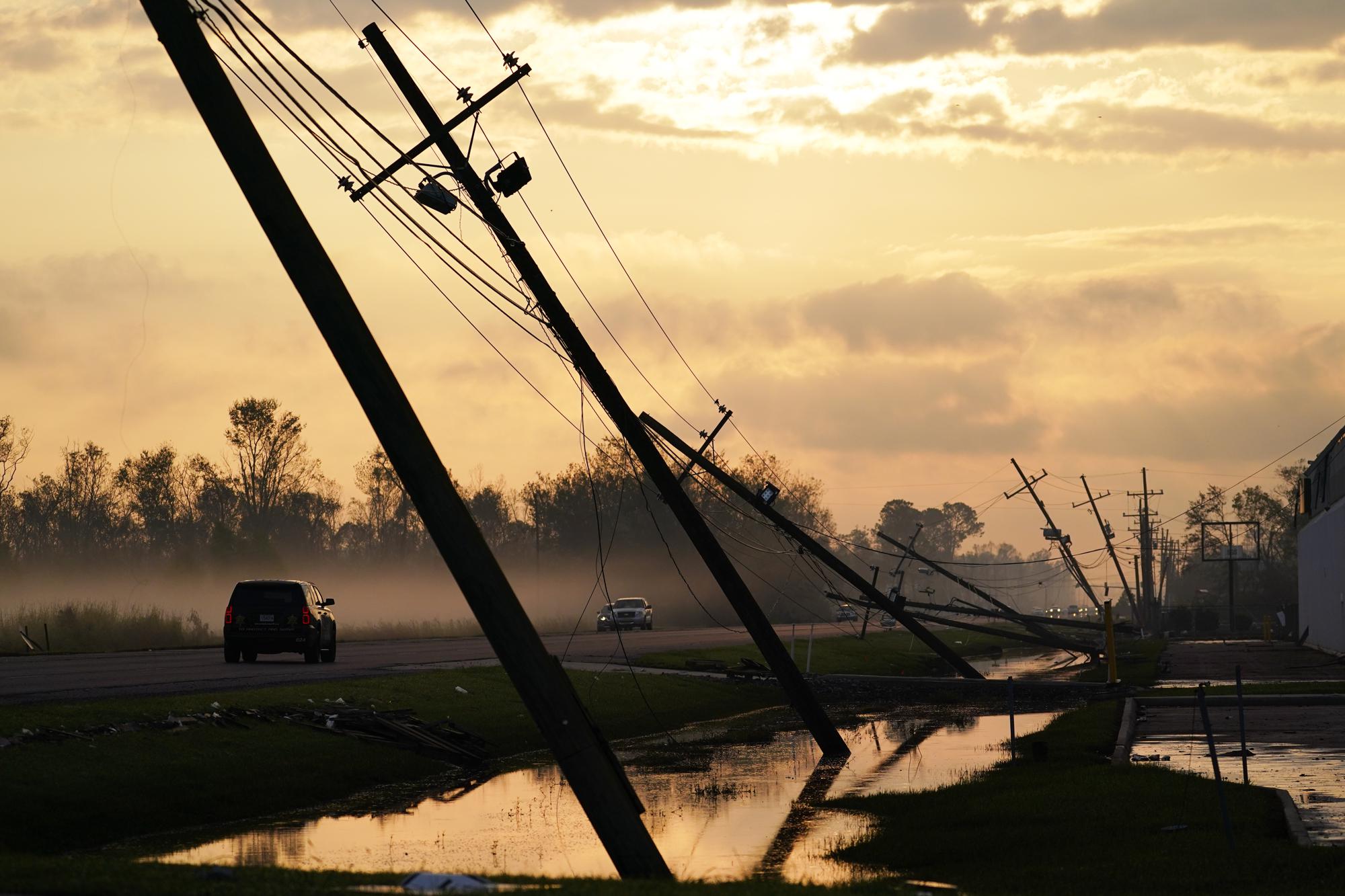 Power lines knocked down by Hurricane Ida lean precariously over a road