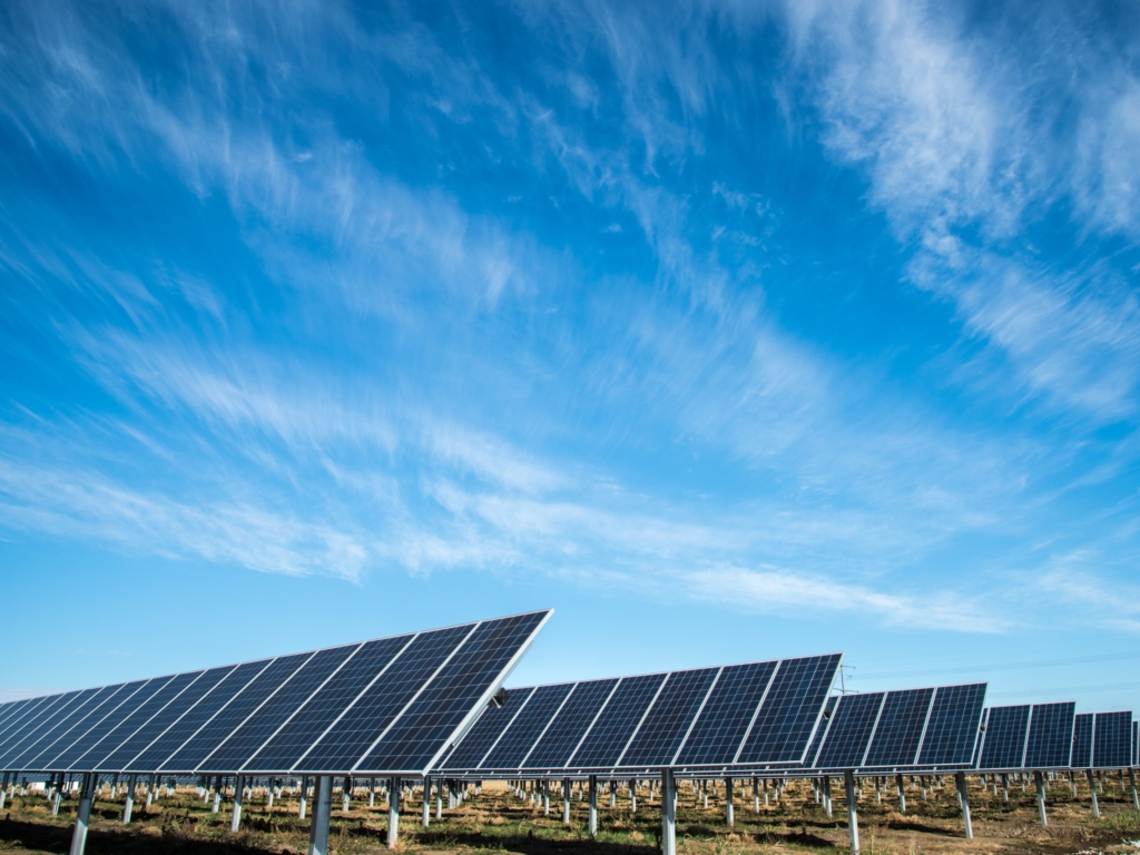 Rows of solar panels under an open sky